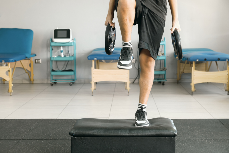 Young Man Undergoing Functional Leg Rehab with Exercise Cube and Weights