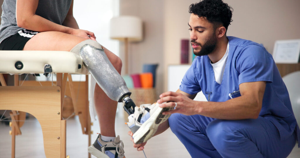 Nurse, amputee and leg with people, consultation and rehabilitation for person with disability. Healthcare, help or appointment for medical prosthetic, physical therapy or man with woman in clinic.